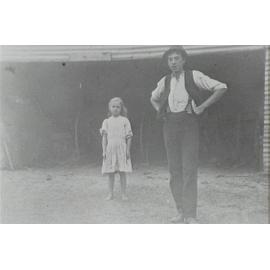 Eva and Arthur Larkin standing near shed on Waratah Farm, Ingleside. 