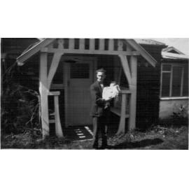 Mr Douglas holding baby June outside the family home in Mona Vale