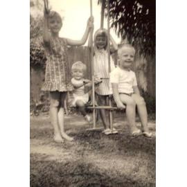 Four of the Baird children on swings in yard at 18 St Andrews Gate, Elanora Heights, 1965
