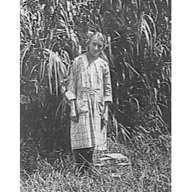 Portrait of a young girl with a caged galah