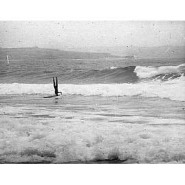 Man doing a head-stand on a surfboard, Freshwater Beach