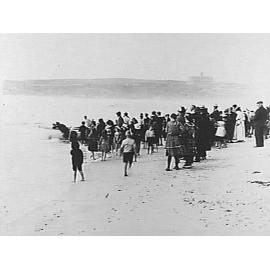 Crowd at Manly Beach watching a boat being launched, c1900