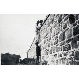 Men climbing the stone wall on North Head