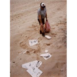 Warringah Council staff member collecting rubbish from the beach