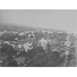 Elevated view over houses and trees, showing a rocky hillside, unidentified location, c1870