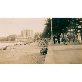 View south along Manly Beach, Manly, with crowds strolling along the esplanade, c1930s