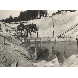 Work crew using water pump in channel duirn rebuilding of sea wall at North Steyne, Manly, 1955