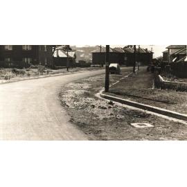 Unidentified street view with curb and maintenance hole, c1940s