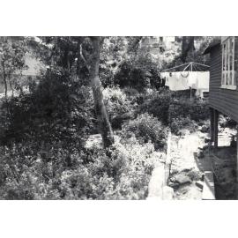 House with garden beds and clothesline, c1940s