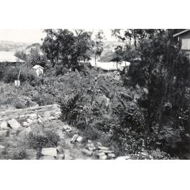 Garden beds on a property overlooking a waterway, c1940s