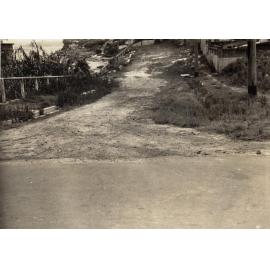 Unsealed section of roadway on unidentified street, c1940s