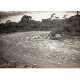 View over waterway from an unsealed roadbend, c1940s