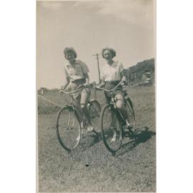 Two women riding bicycles, Narrabeen, 1943