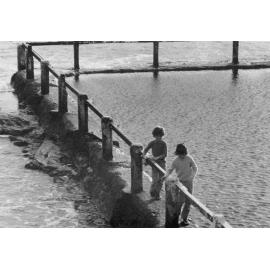 Two children walking along the edges of a rockpool, c1967-1973
