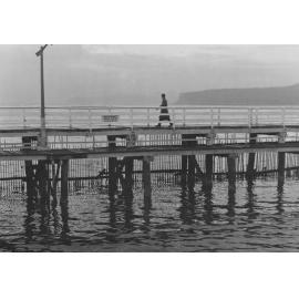A person walking across the old Manly boardwalk, Manly, c1967-1973
