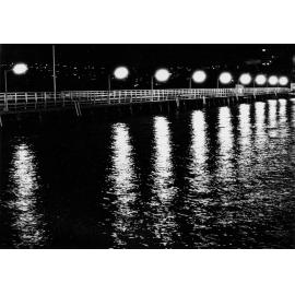 The old Manly boardwalk illuminated at night, Manly, c1967-1973
