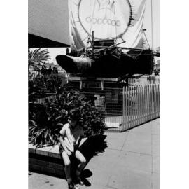Boy seated near a sailing vessel display at Warringah Mall, Brookvale, c1967–1973
