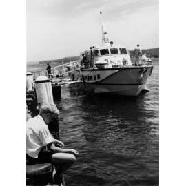 Boy fishing on the Manly Wharf in front of a hydrofoil, Manly, c1967–1973
